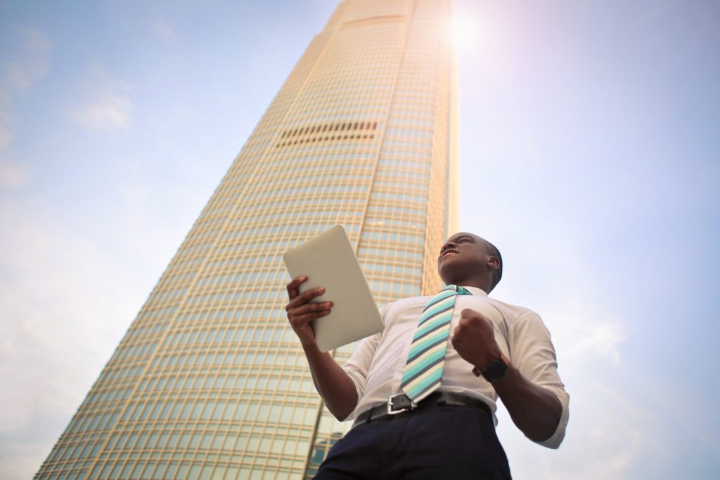 Young Man standing under tall building